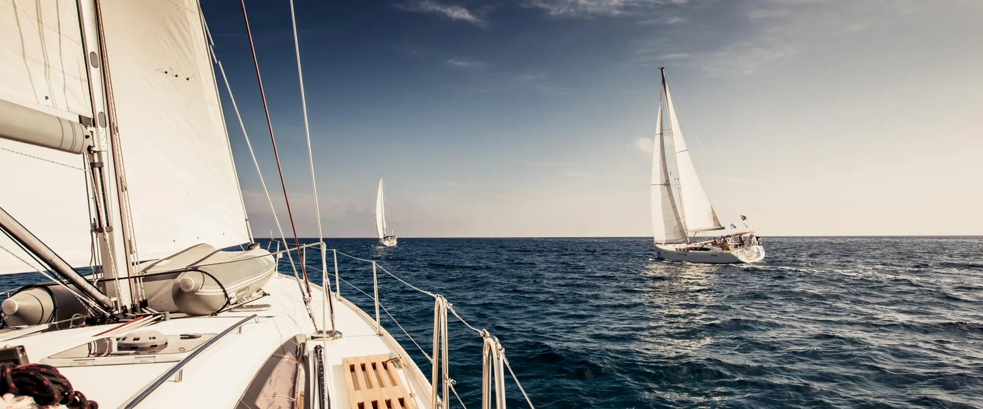 A sailing yacht navigating the vast, open sea with gentle waves surrounding it.